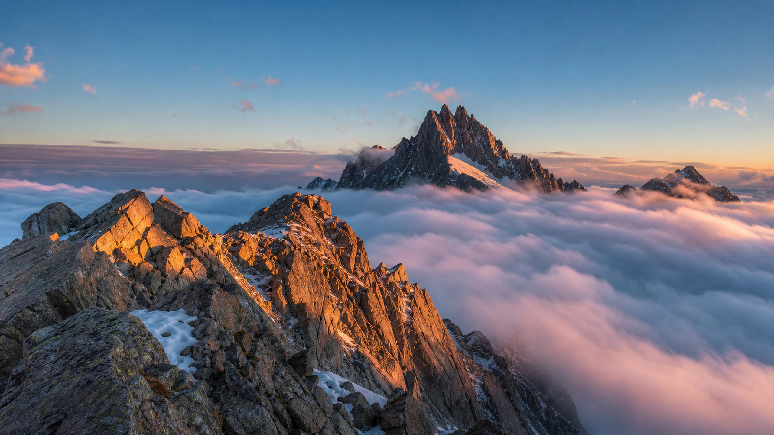 High rocky ridge above a sea of clouds, isolated peaks burning with dawn light, original 4K mountains wallpaper