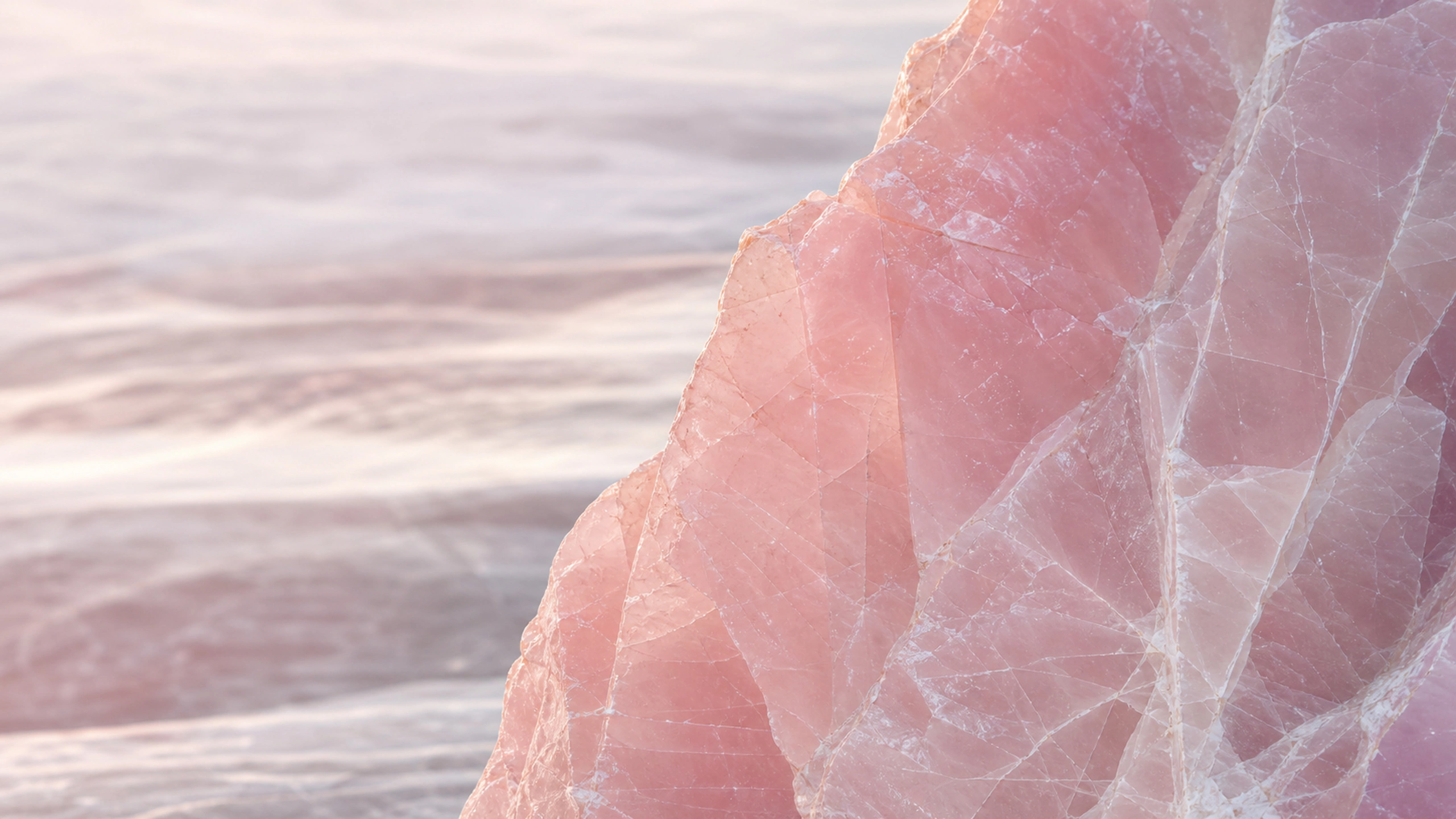 Translucent rose quartz intersected by pale fractures under controlled side light, original 4K textures wallpaper