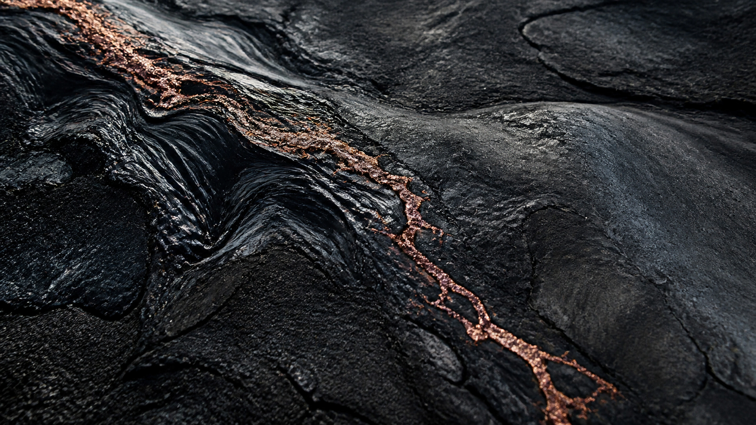 Black volcanic glass crossed by a thin copper-colored mineral vein, deep tactile detail, original 4K textures wallpaper
