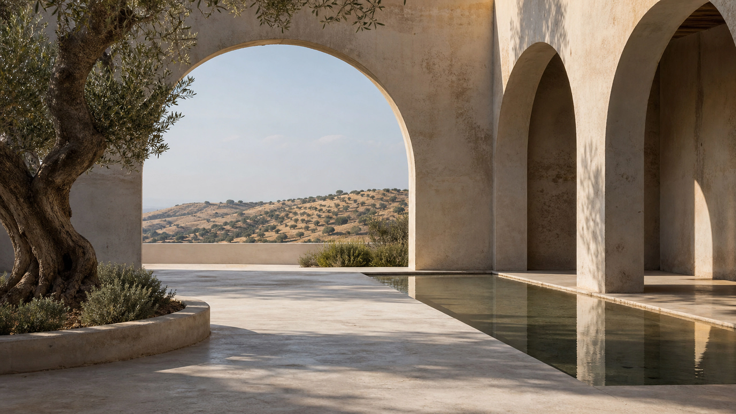 Open arched courtyard framing a distant dry hillside, aged stone and afternoon shadow, original 4K architecture wallpaper