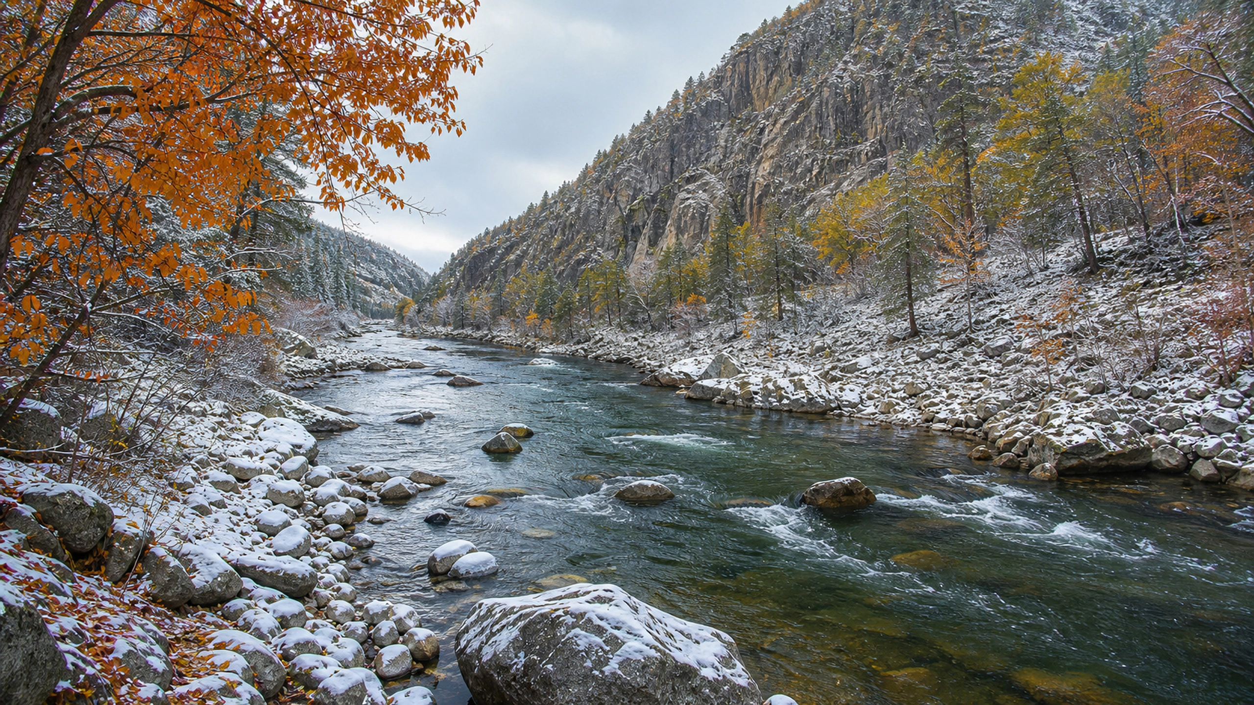 Fresh snow edging an autumn river while copper leaves remain on nearby trees, original 4K lakes rivers wallpaper