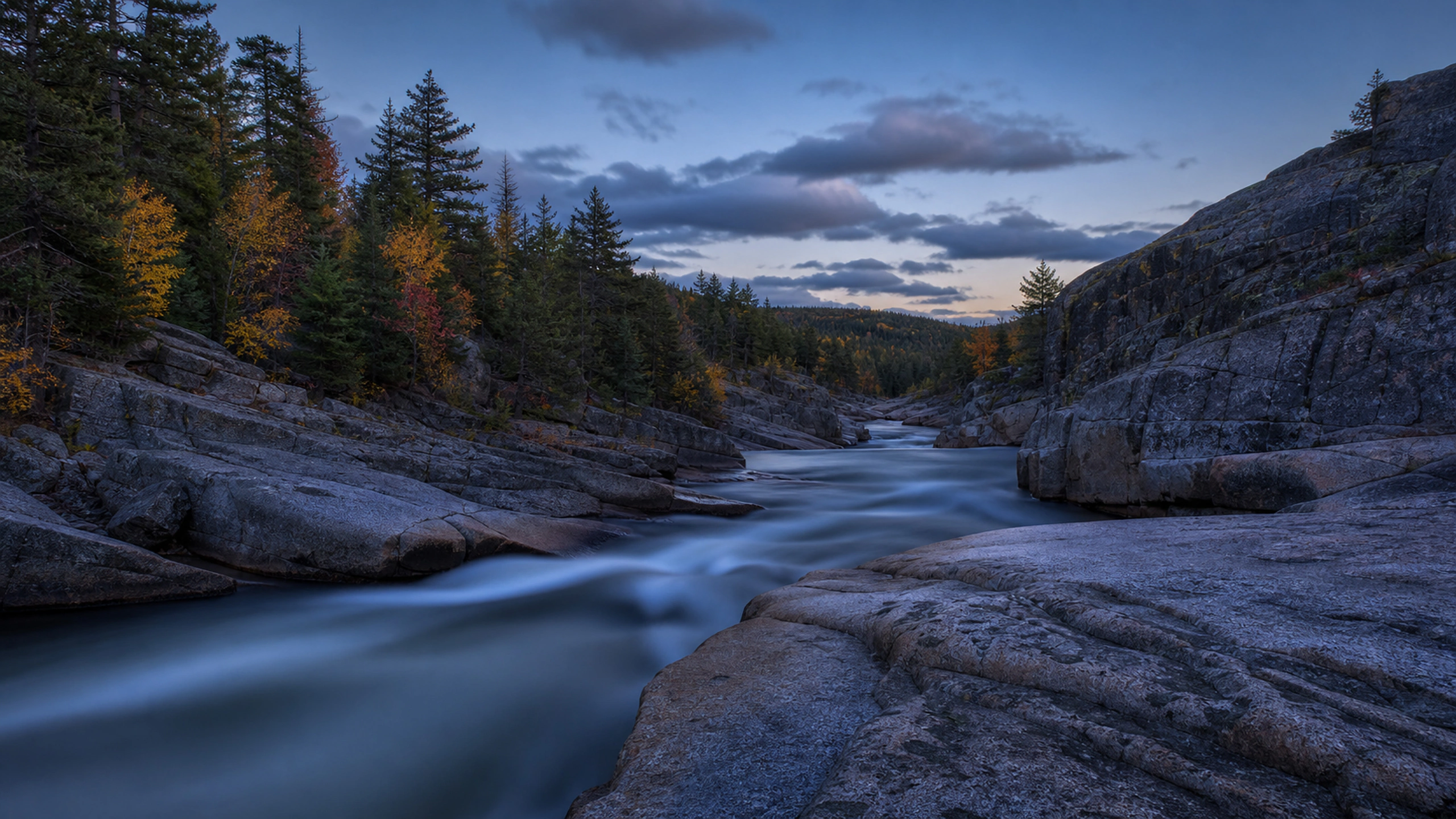 Long-exposure-like natural smooth current through granite at quiet blue hour, original 4K lakes rivers wallpaper
