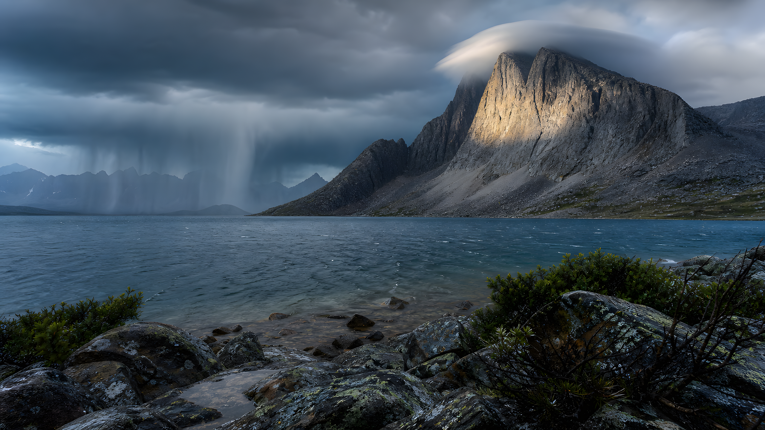 An unnamed high-latitude granite massif above a deep teal glacial lake with scree fans, wind-twisted shrubs and moving rain curtains, photographed from a very low wet-stone shoreline during a brief sun break, original 4K nature wallpaper
