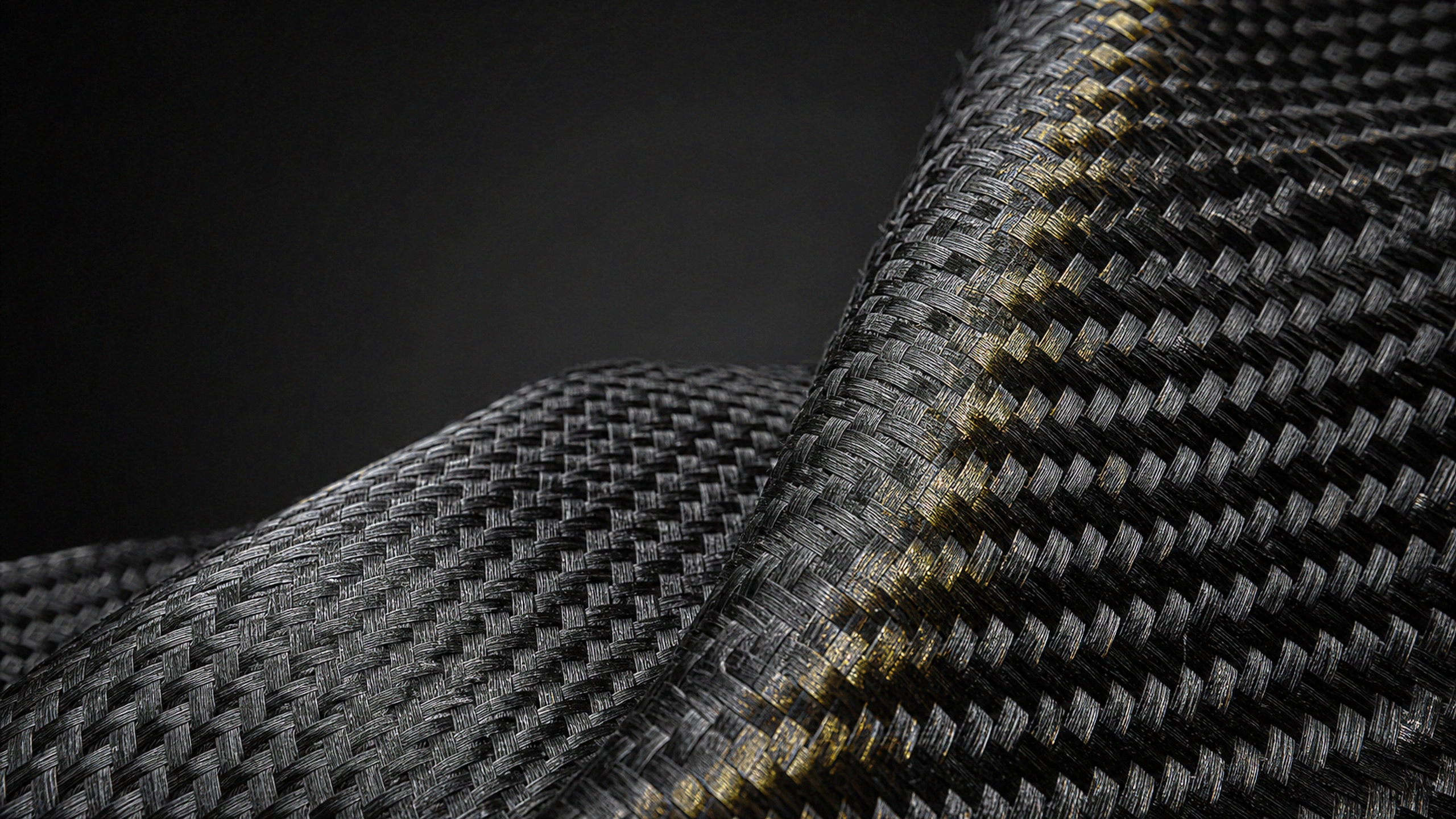 Macro landscape of woven black carbon fibers crossed by one subtle gold interference band, perfectly resolved weave and material depth, original 4K dark amoled wallpaper