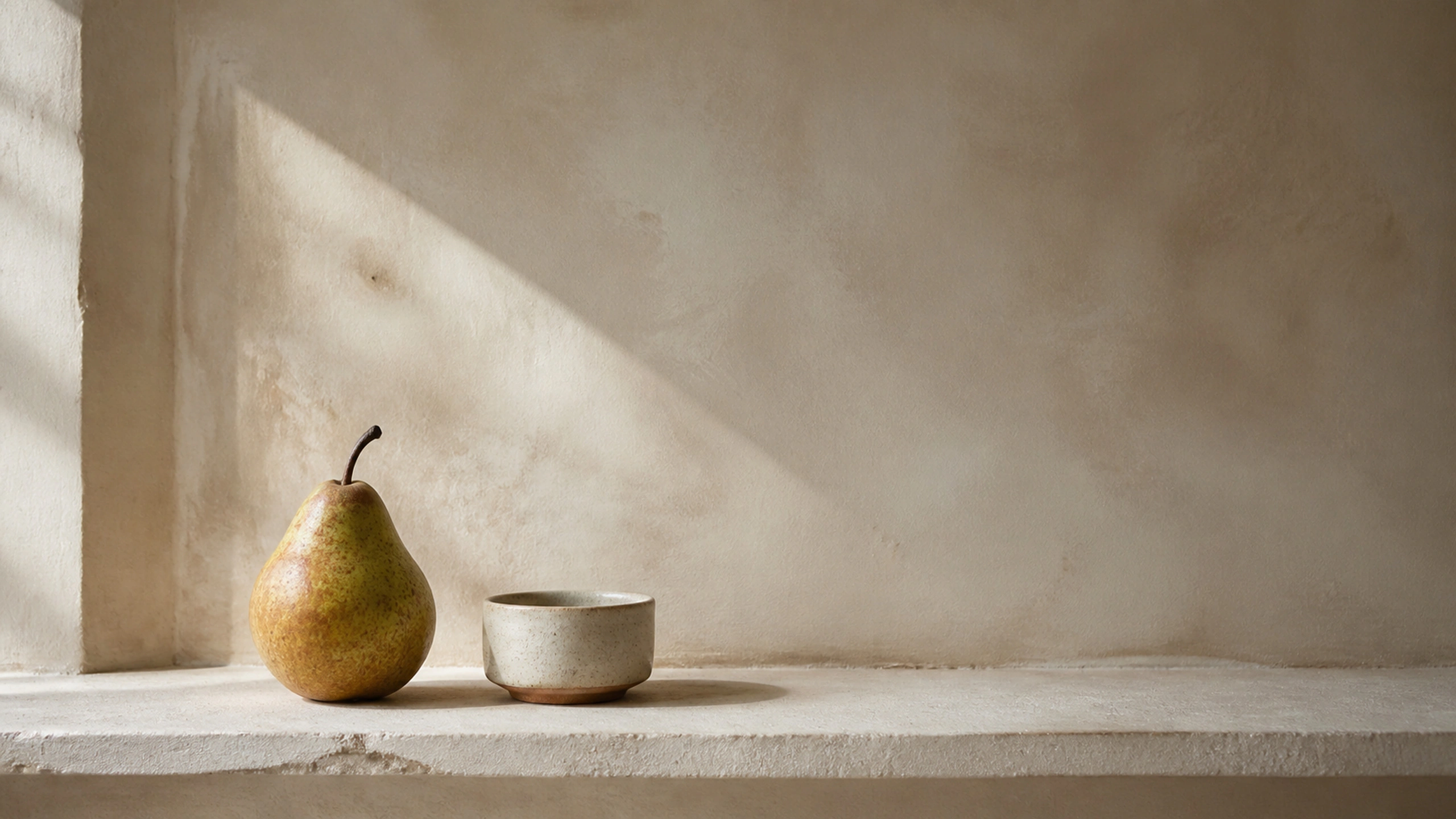 One pear and one low ceramic cup on a limewashed shelf with generous negative space, original 4K still life objects wallpaper