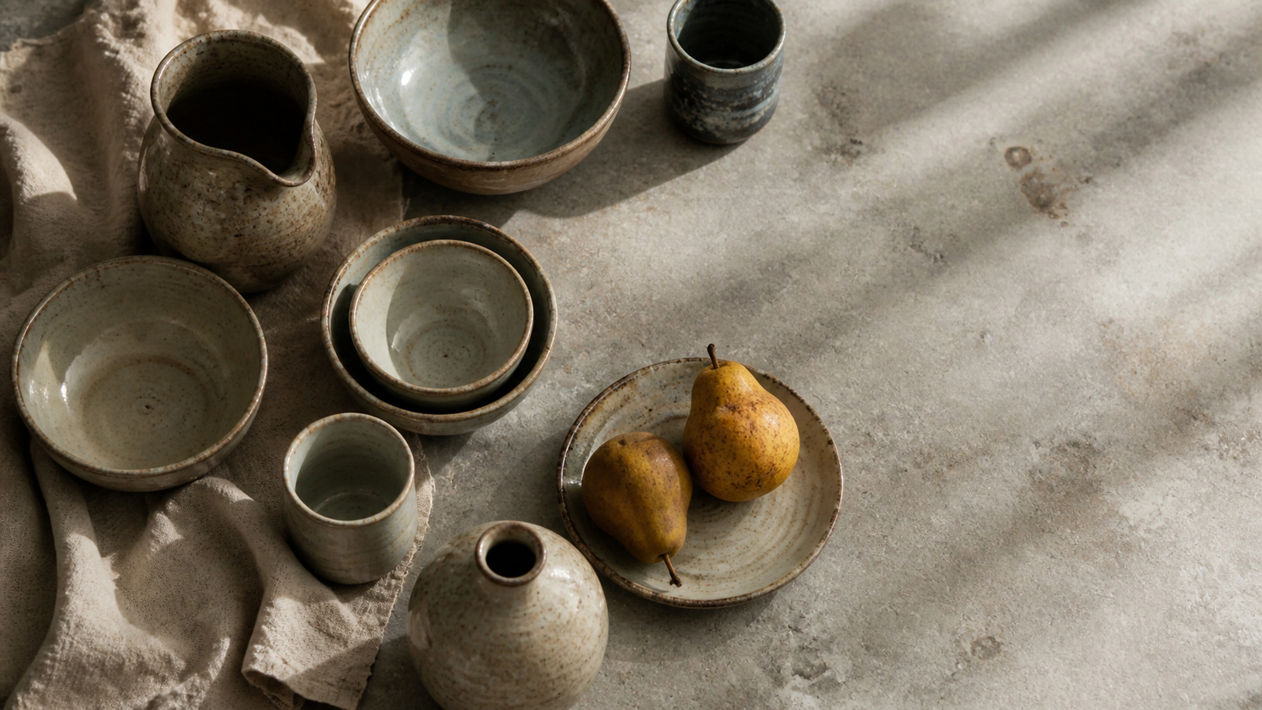 Varied wheel-thrown ceramics surrounding two small pears, top-down natural composition, original 4K still life objects wallpaper