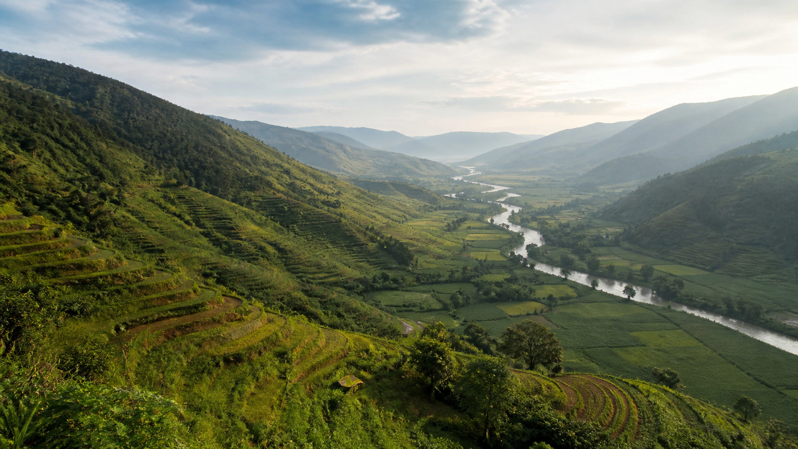 Elevated viewpoint across terraced green hills and an empty valley floor, original 4K nature wallpaper
