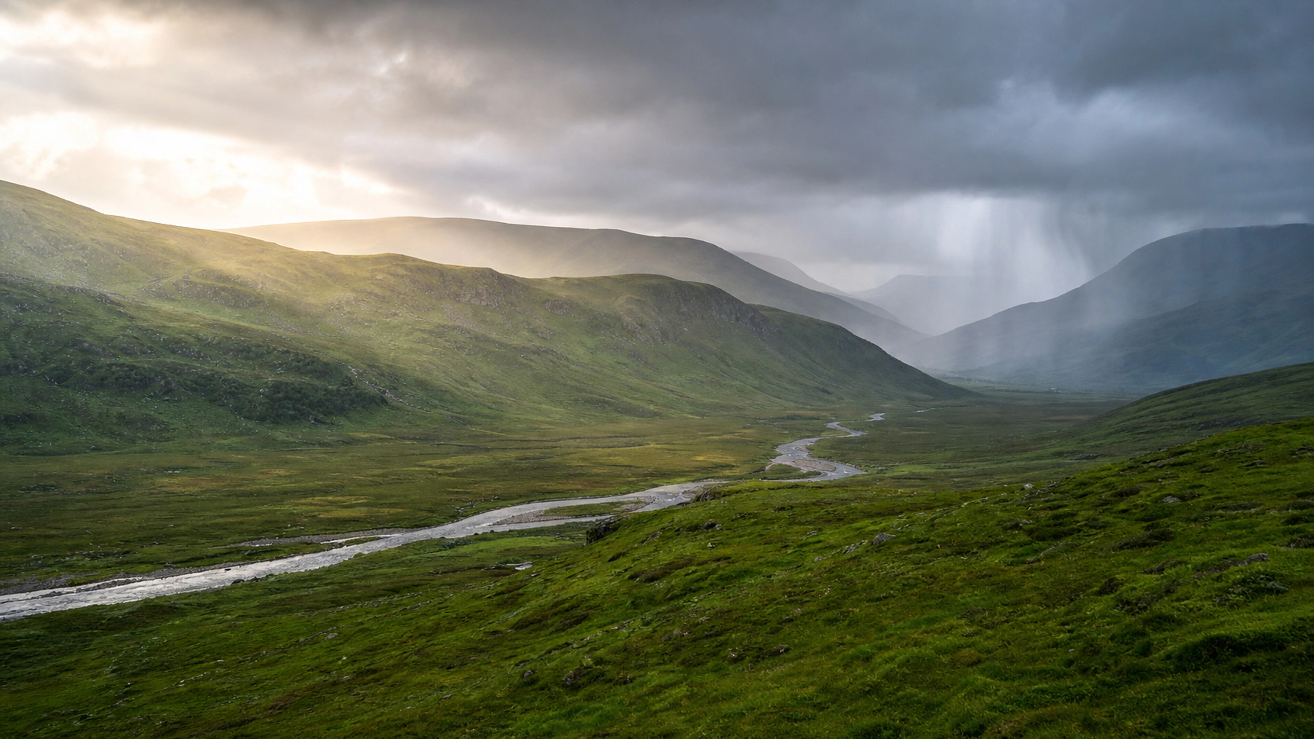 Quiet green valley foreground with a realistic rain shower crossing distant hills, original 4K nature wallpaper
