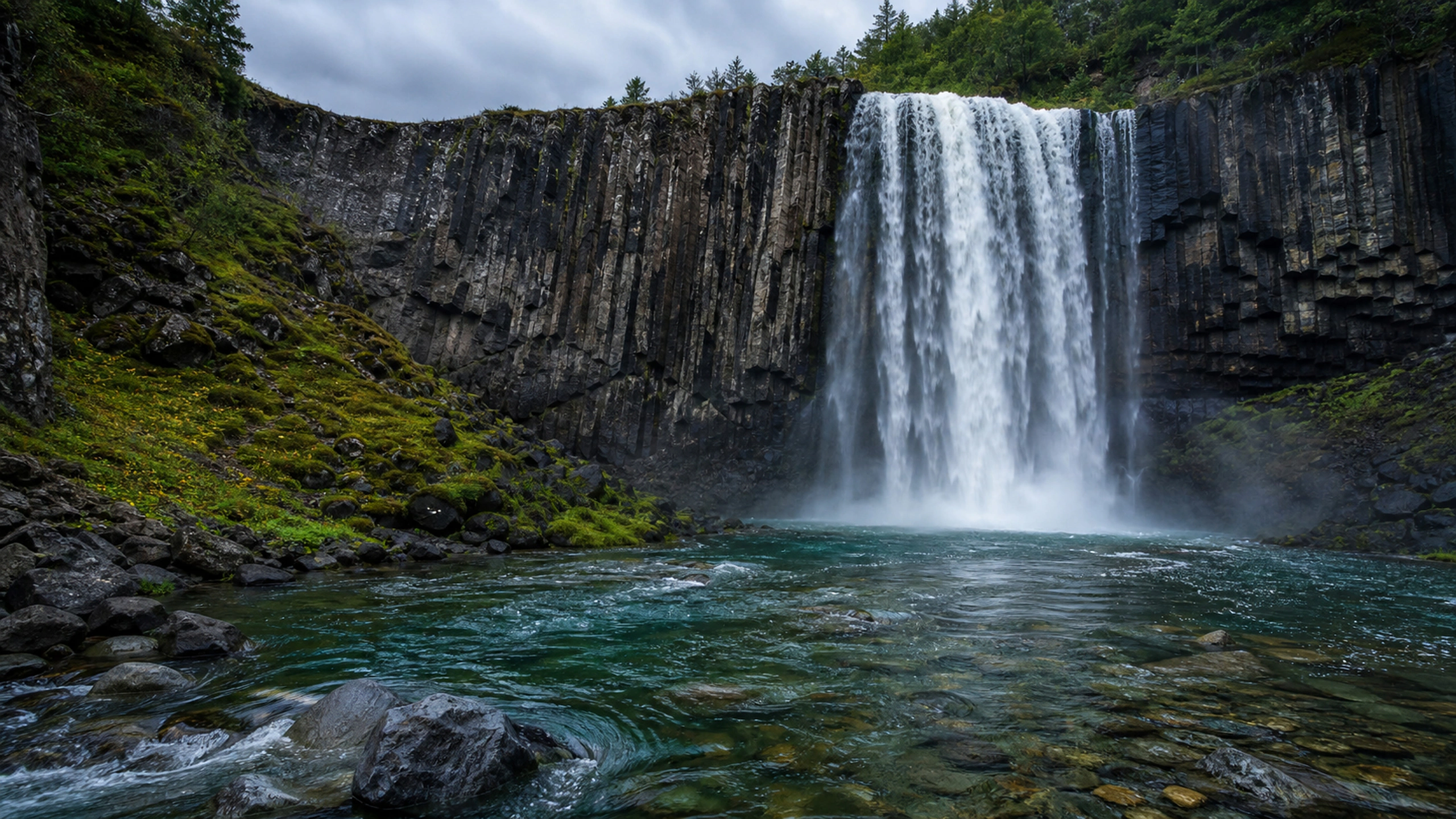 Broad waterfall descending over dark columnar basalt into a clear river, original 4K lakes rivers wallpaper