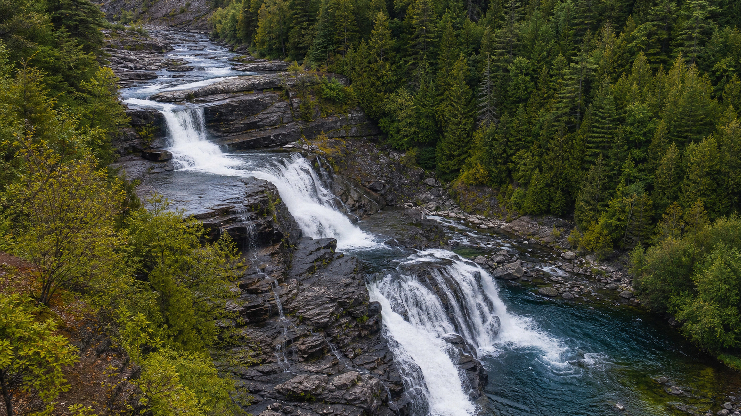 High oblique view of a wilderness river dropping through several natural falls, original 4K lakes rivers wallpaper