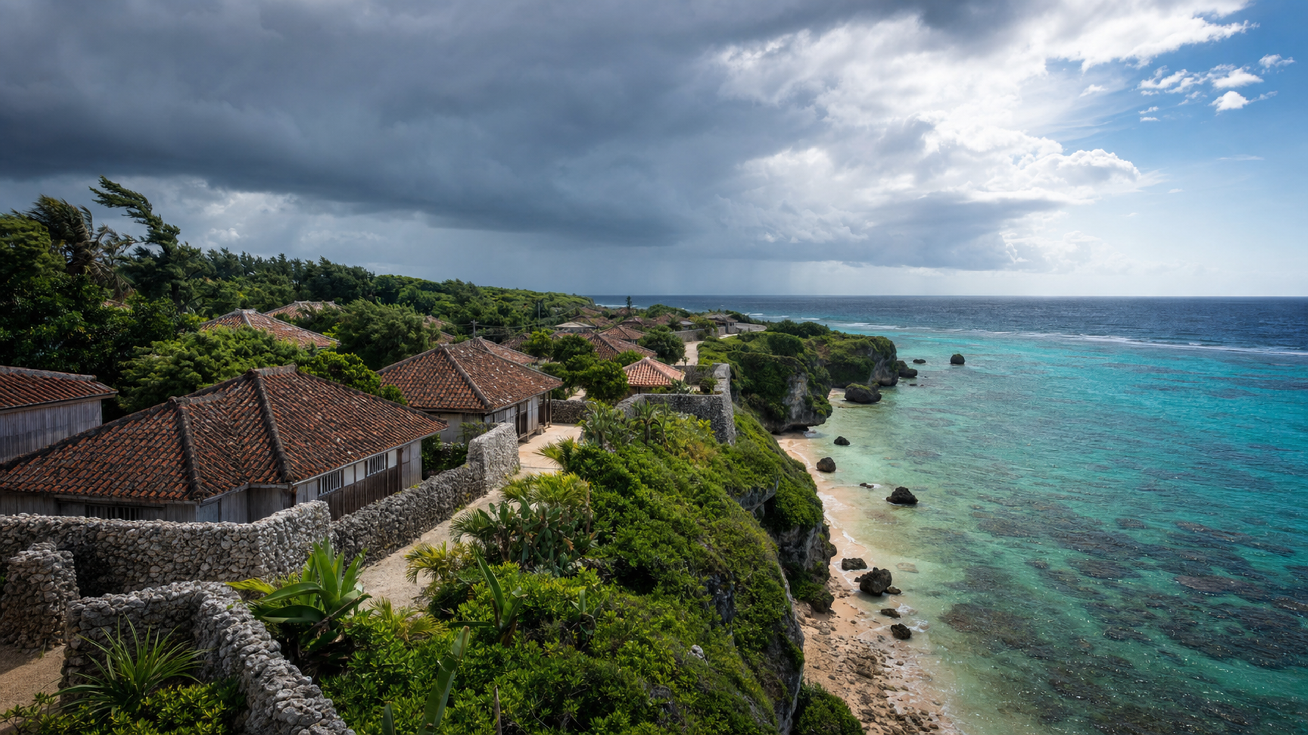 Weathered coral-stone walls and wind-shaped subtropical trees above a remote turquoise coast beneath bright broken cloud, original 4K travel wallpaper