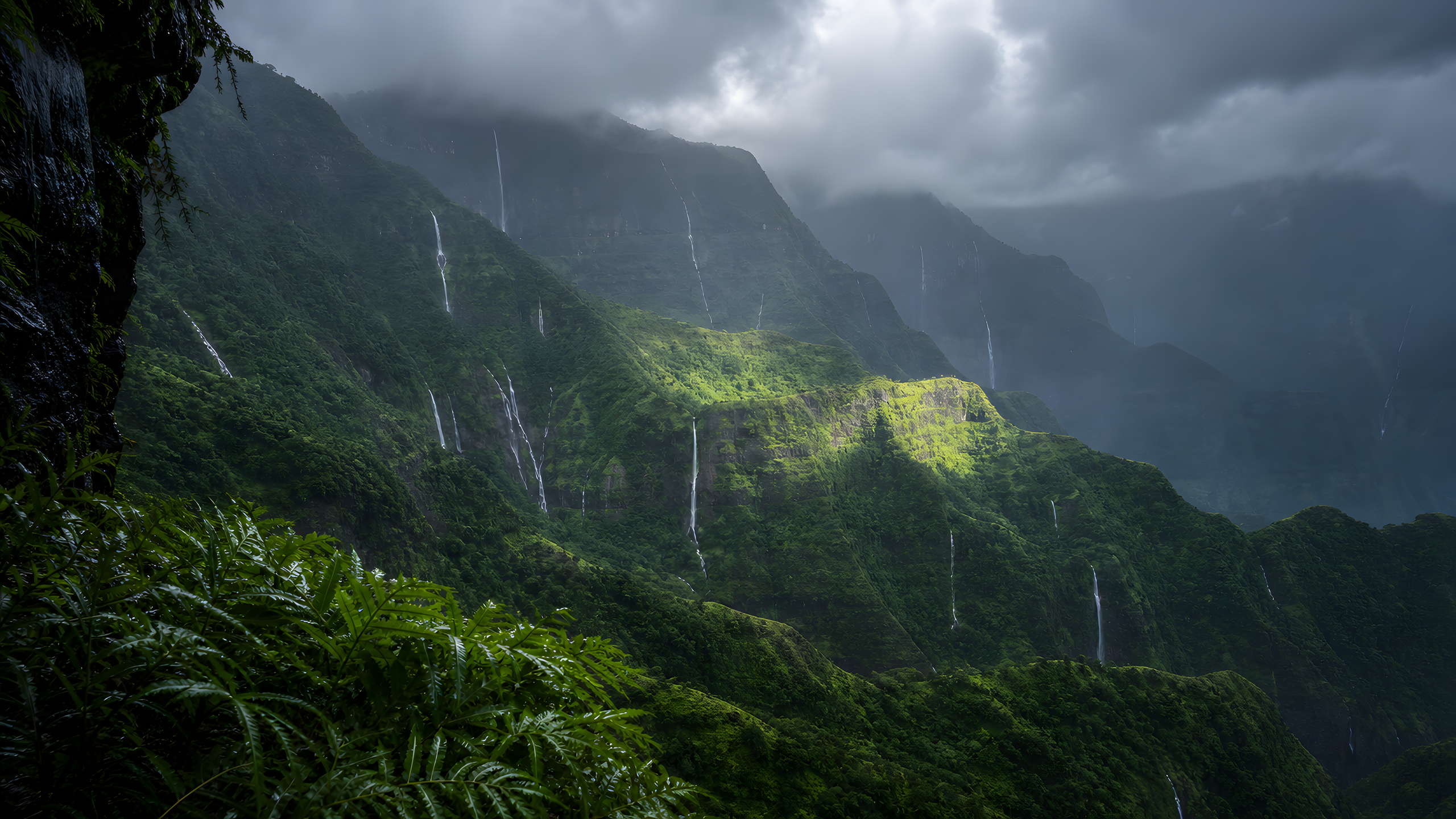 Densely folded subtropical green mountains after heavy monsoon rain, with thin temporary waterfalls, rolling cloud and one restrained sunbreak across a middle ridge, original 4K mountains wallpaper