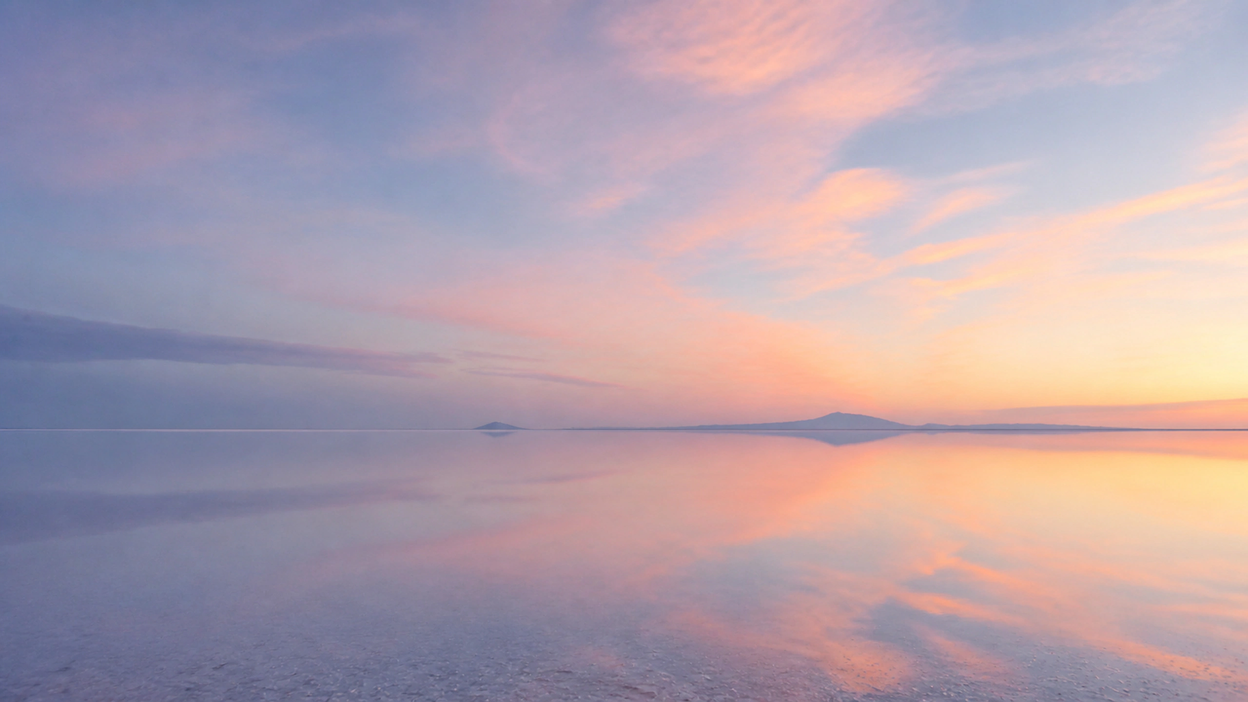 Thin reflective salt-flat horizon beneath a vast blush and blue morning sky, original 4K pastel wallpaper
