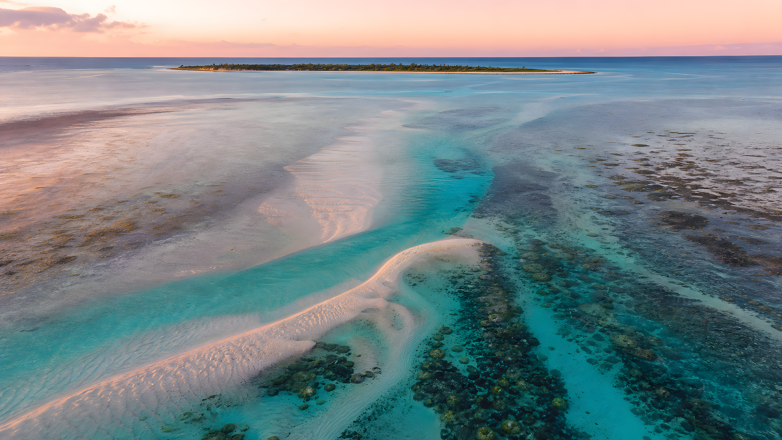 A pristine tropical lagoon with pale sandbars, branching coral gardens, clear aquamarine channels and a distant uninhabited island, seen from a high aerial beneath peach-pink dawn light, original 4K pastel wallpaper