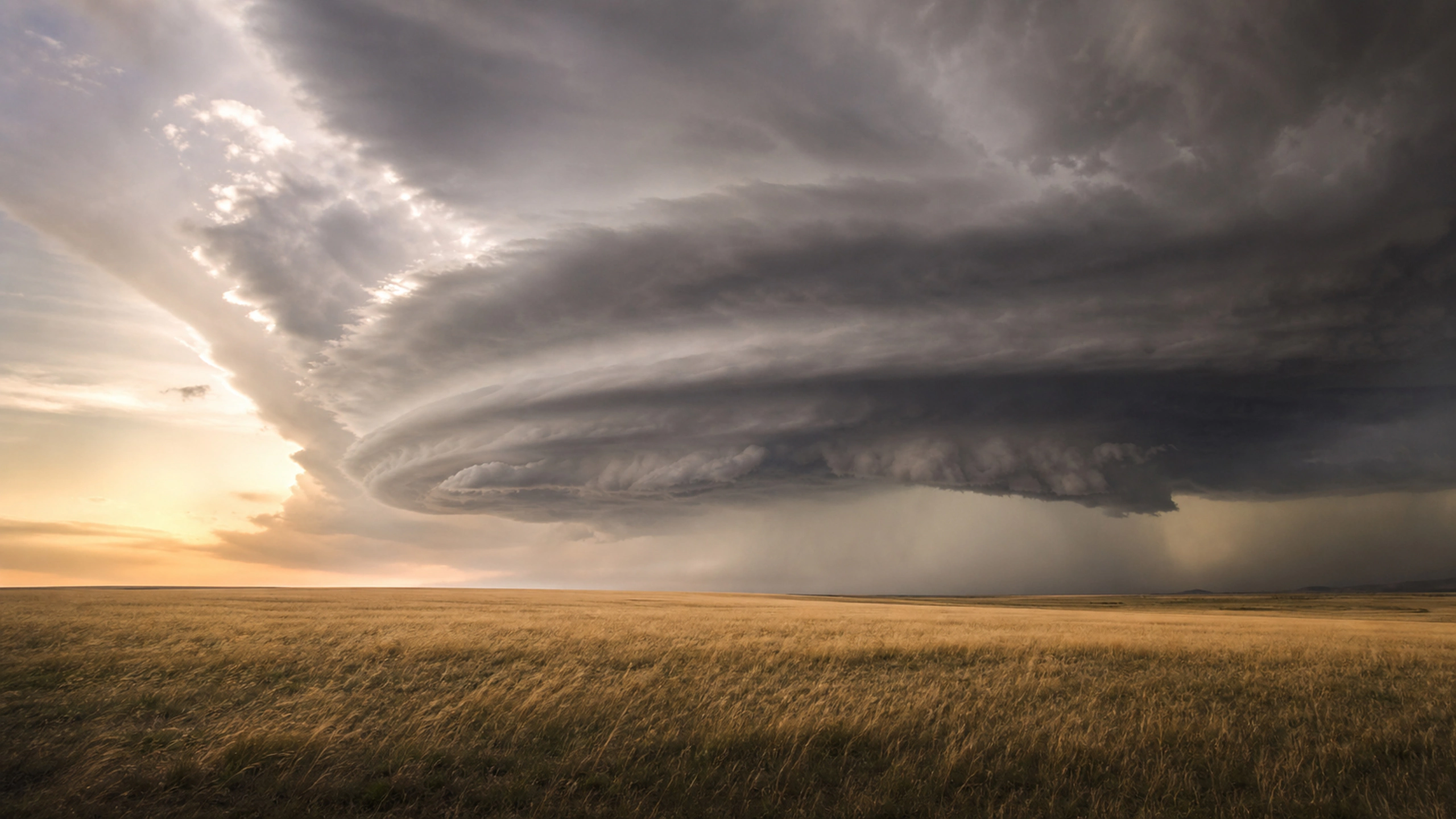Photorealistic rotating supercell seen safely across a vast treeless landscape, original 4K weather wallpaper