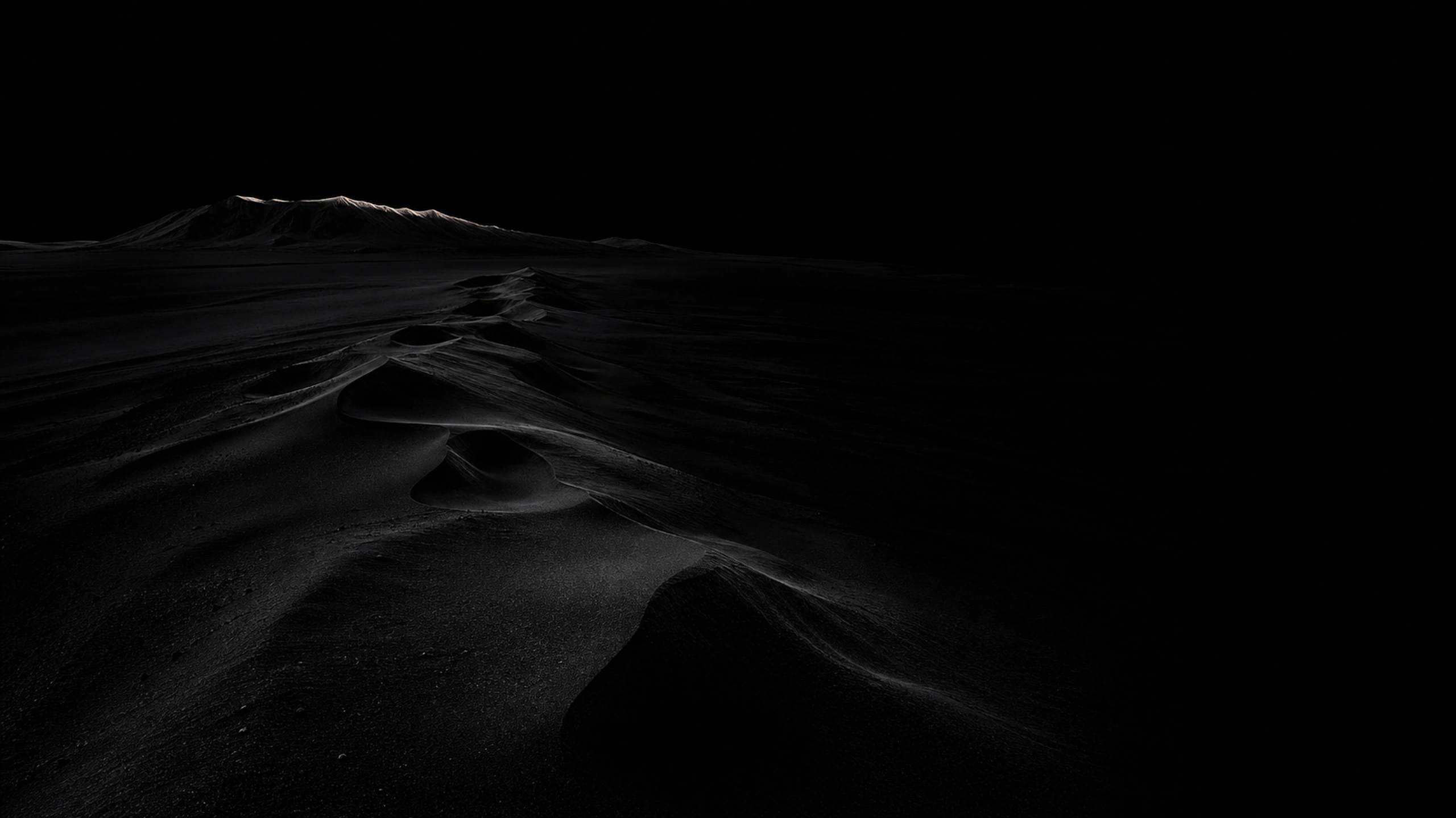 Wind-sculpted near-black volcanic dunes crossing a vast empty basin, one fine silver dawn edge and immense true-black sky, original 4K dark amoled wallpaper