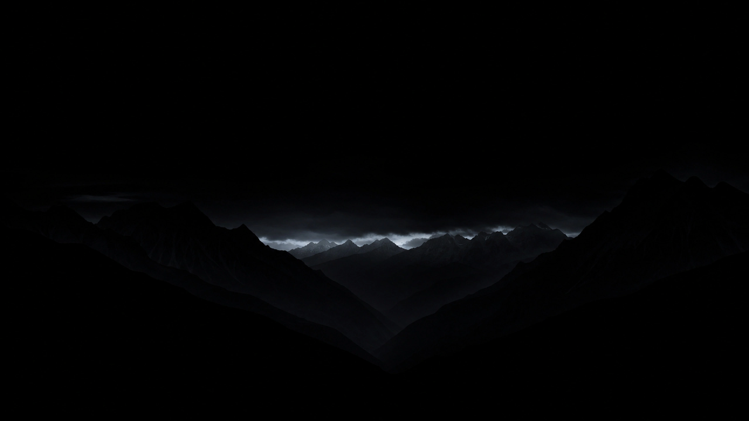 Layered alpine ridges reduced to charcoal-black silhouettes, a distant cold cloud break and generous unlit sky, original 4K dark amoled wallpaper