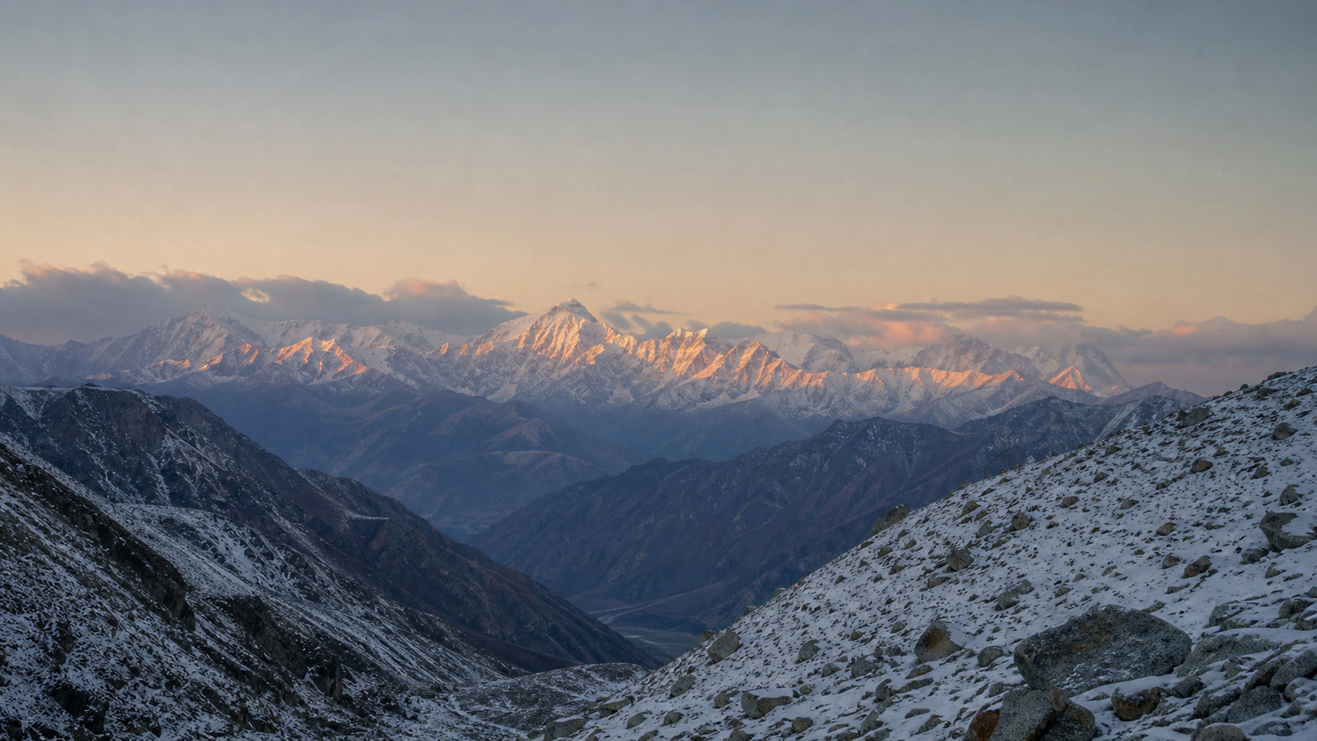 Distant snowy range glowing softly beyond a shadowed alpine valley, original 4K mountains wallpaper