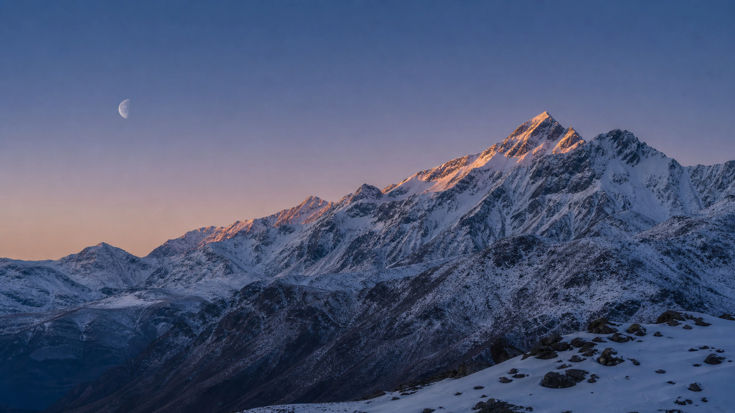 Pale setting moon above cold snow ridges just before dawn, original 4K mountains wallpaper