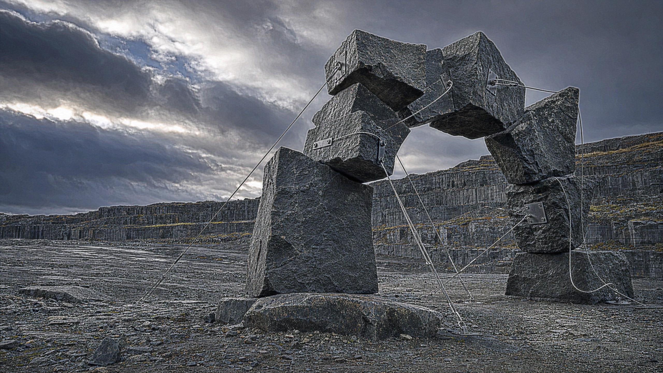 Rough black basalt blocks counterbalanced around a cable-supported negative-space arch in a windswept stone quarry, individual mineral grains, steel cable strands and chipped edges sharply visible, original 4K 3d renders wallpaper