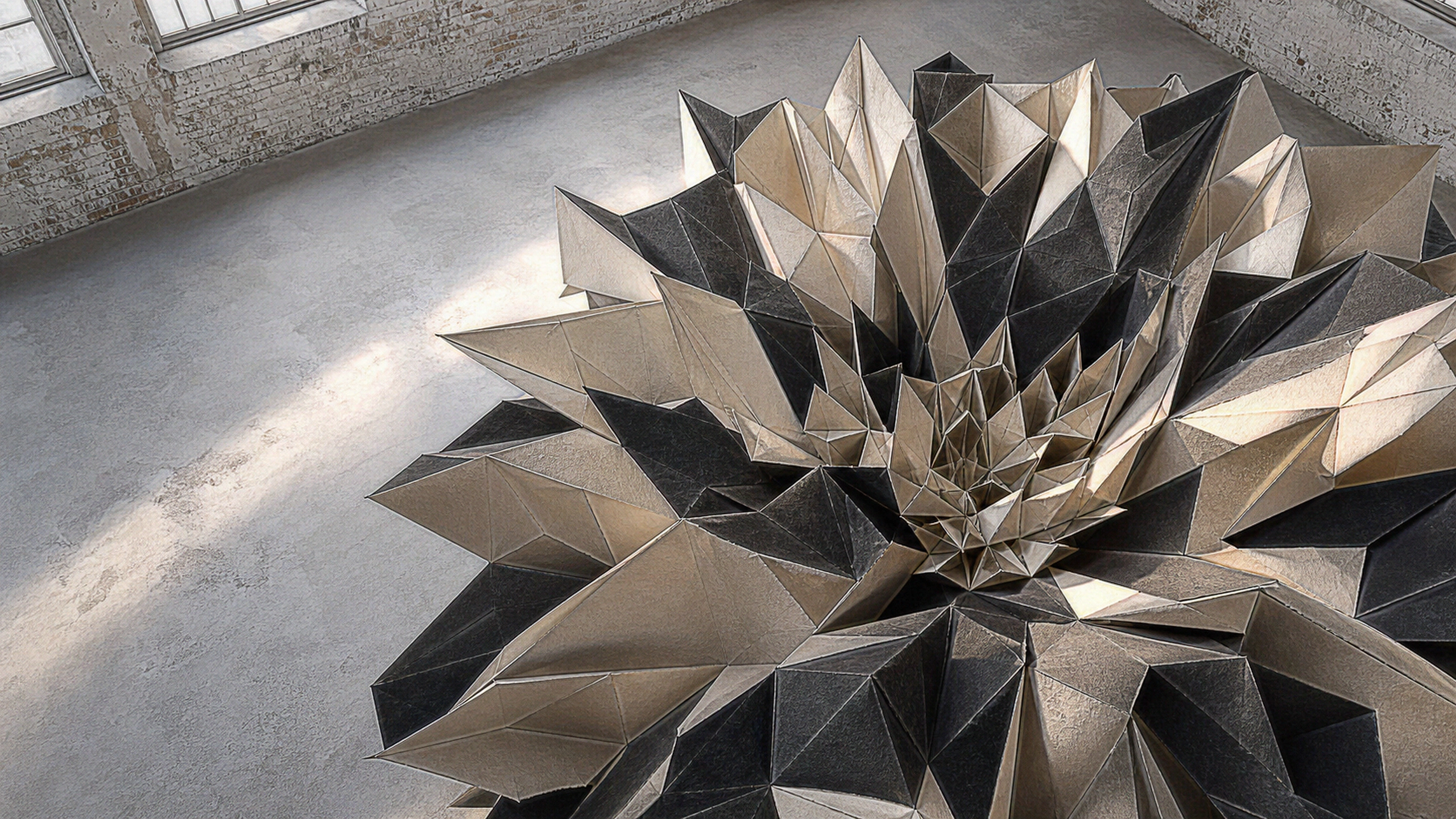 A large geodesic bloom folded from handmade black and cream paper on a pale studio floor, hundreds of unique facets, deckled fibers, creases and precise self-shadows, original 4K 3d renders wallpaper