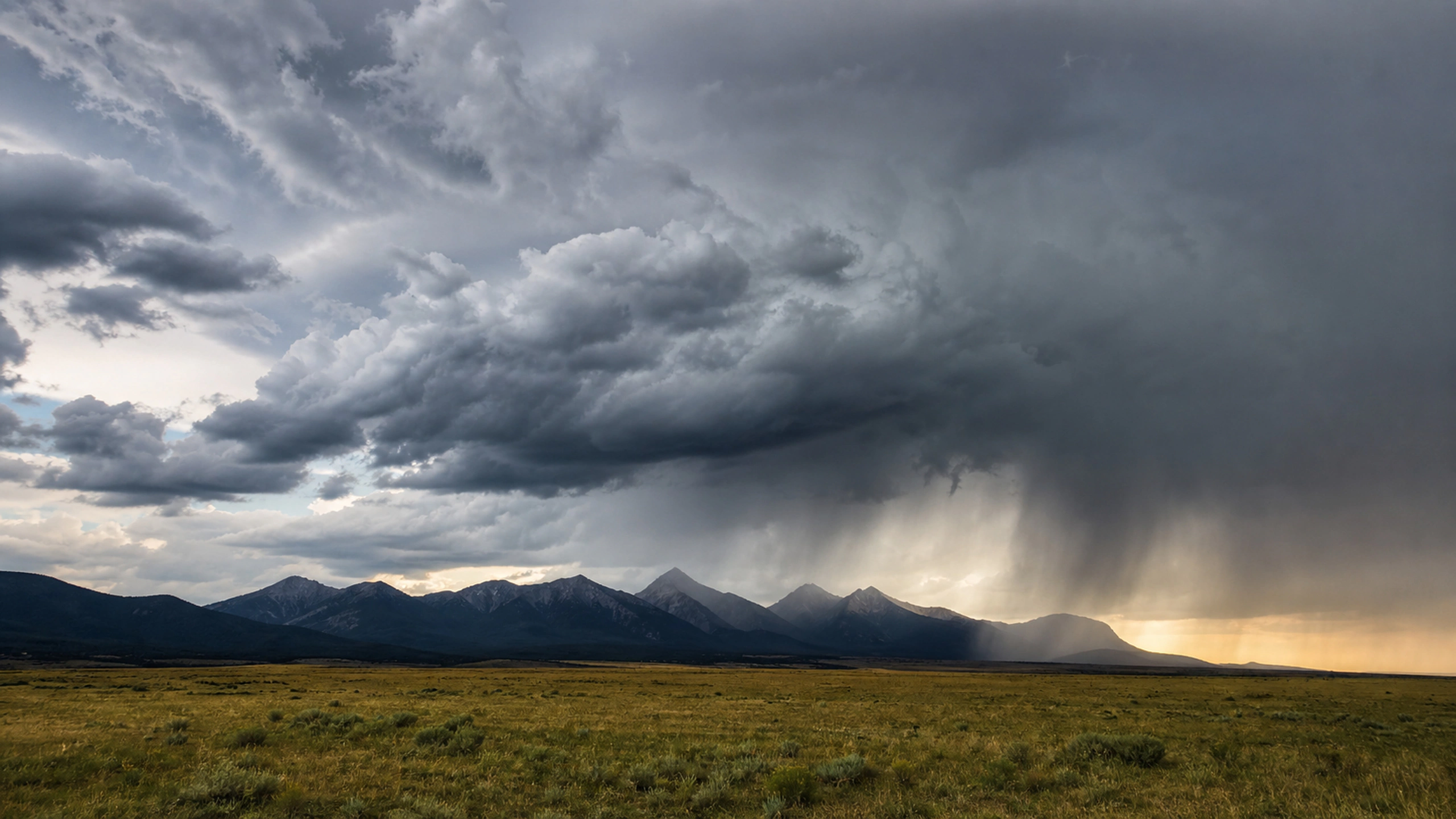 Thunderstorm forming behind shadowed mountains with realistic cloud scale, original 4K weather wallpaper
