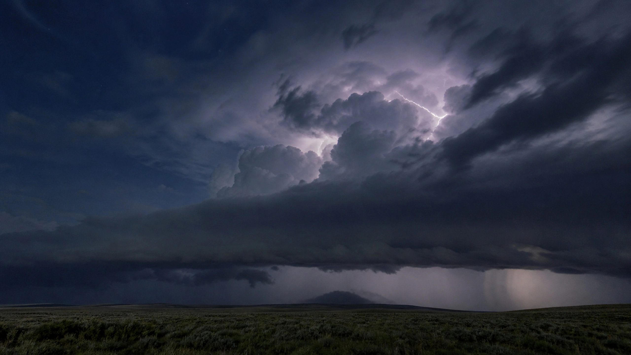 Subtle internal lightning illuminating a structured night thundercloud without oversaturation, original 4K weather wallpaper